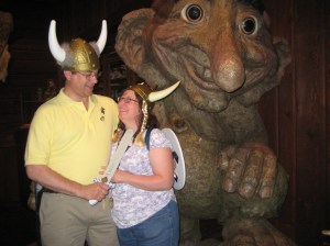 KellieAnn's parents pose in front of a troll statue in the Norway Pavilion of Epcot. 